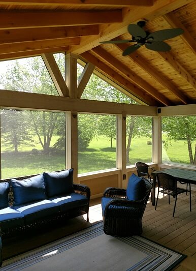 Seating area on screened porch with backyard view