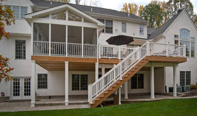 Custom backyard deck and screened porch with white railing