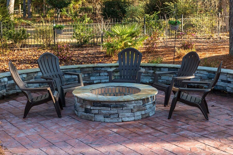 Custom backyard patio with fire pit and seat wall