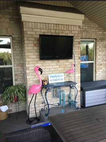 Flat TV on wall and pink flamingo decors