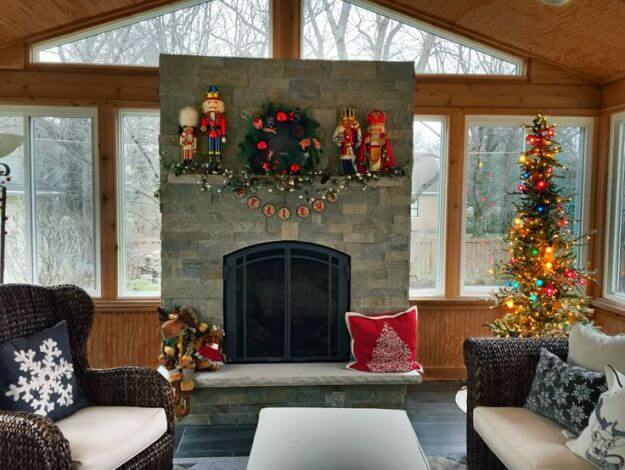 Outdoor fireplace on screened porch with Christmas decors