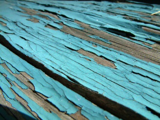Peeling blue paint on wood deck.