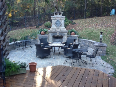 This deck in Irmo SC overlooks a serene hardscape patio with outdoor fireplace
