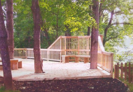 This lakeside pressure treated deck includes built in bench seating, and unique privacy railing. We also integrated the existing trees within the landscape into the design of the deck- stunning.