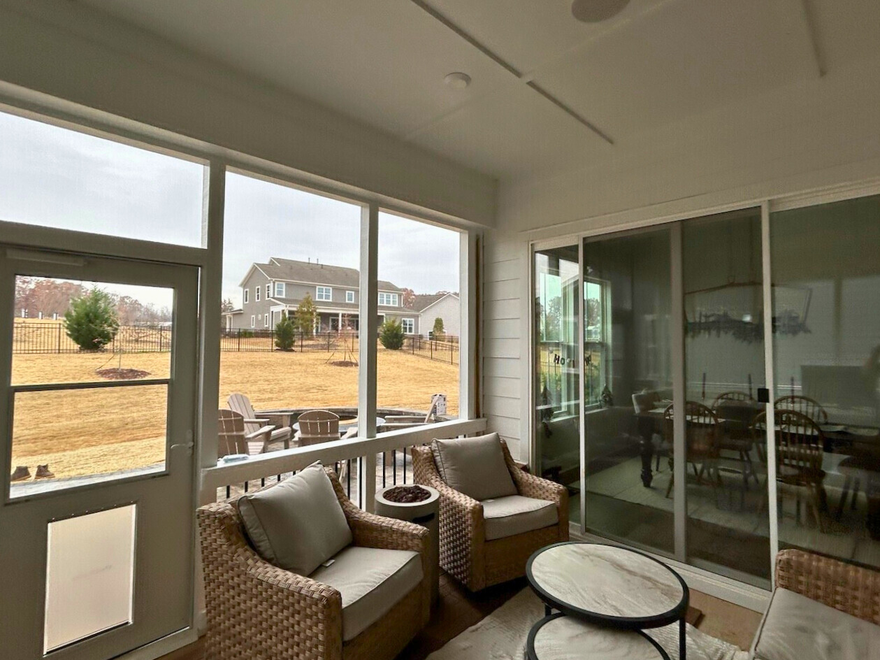 Relax and unwind in this inviting screened porch, offering bug-free comfort and picturesque views – a perfect addition from a top screened porch builder in Belmont, NC.