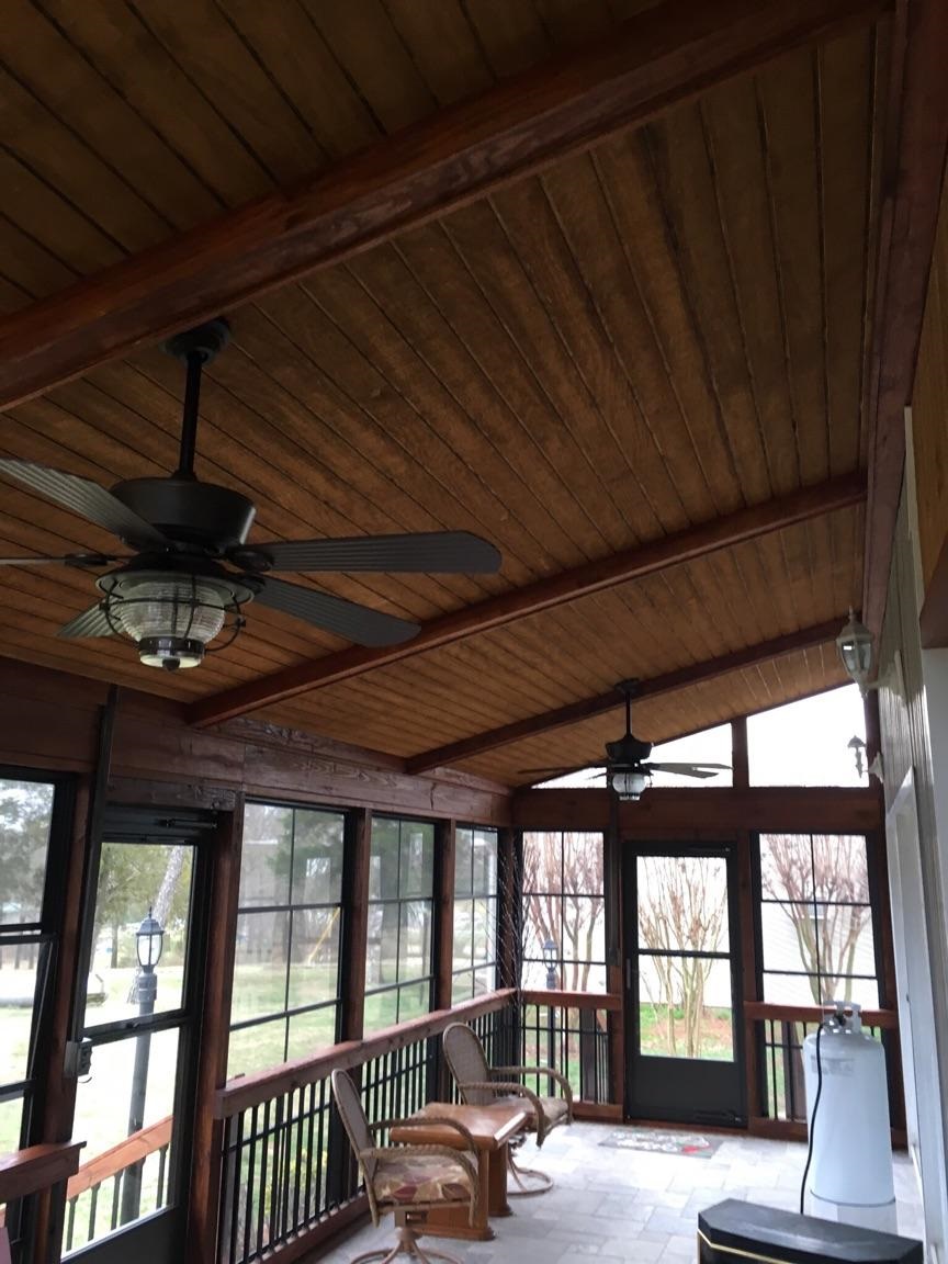 enclosed patio with ceiling fans and slanted wood ceilings