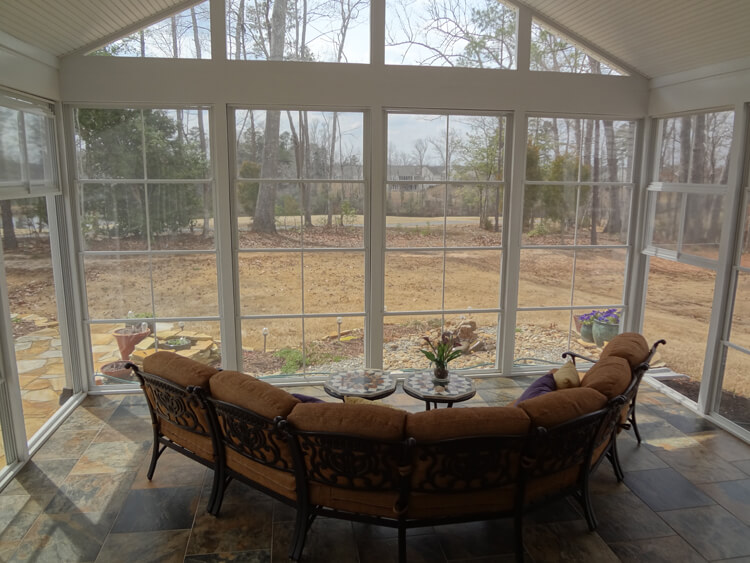 Full window sunroom with backyard view