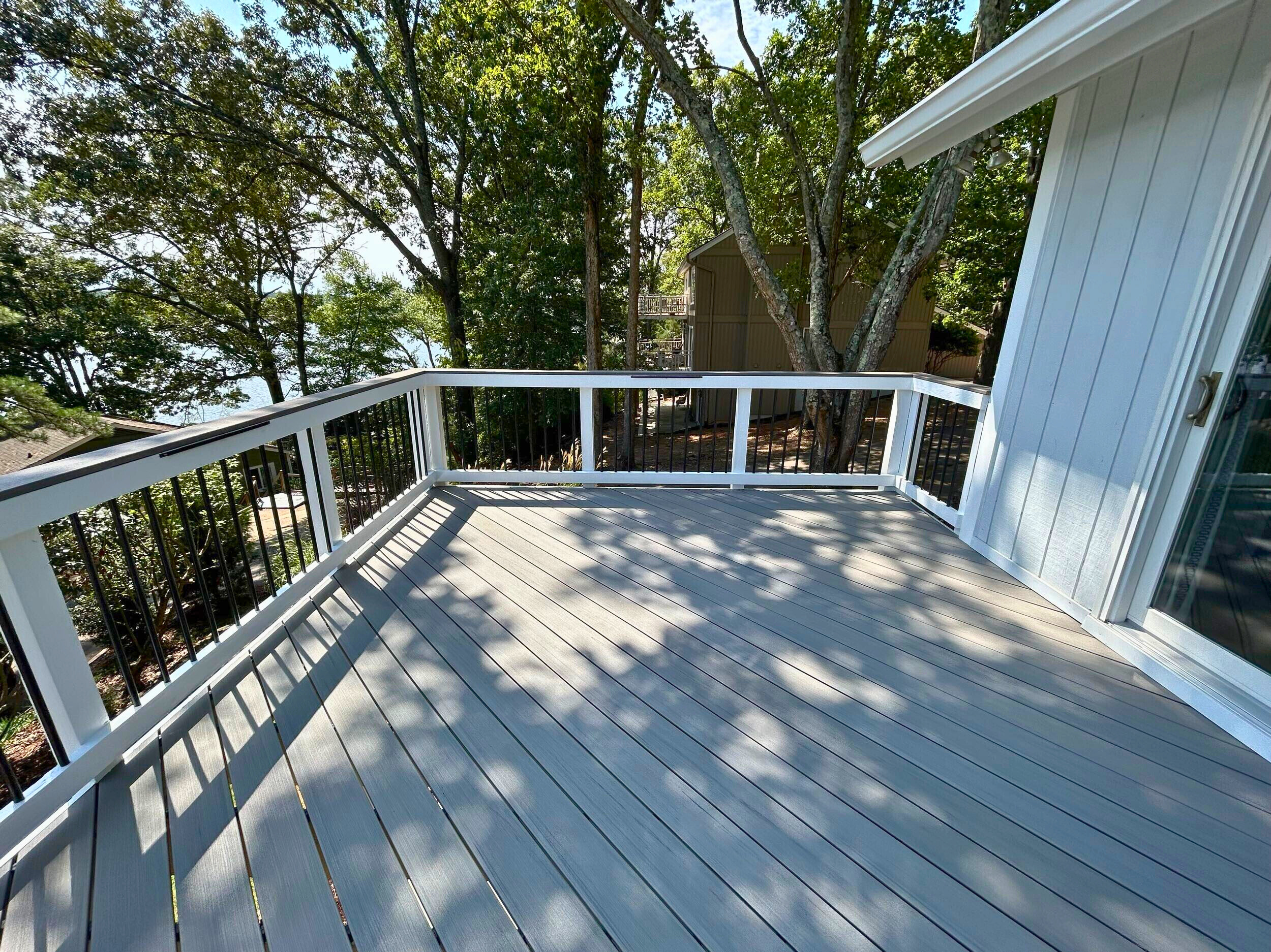 Grey Composite deck with a view of the woods from a Fort Mill backyard, by Archadeck.