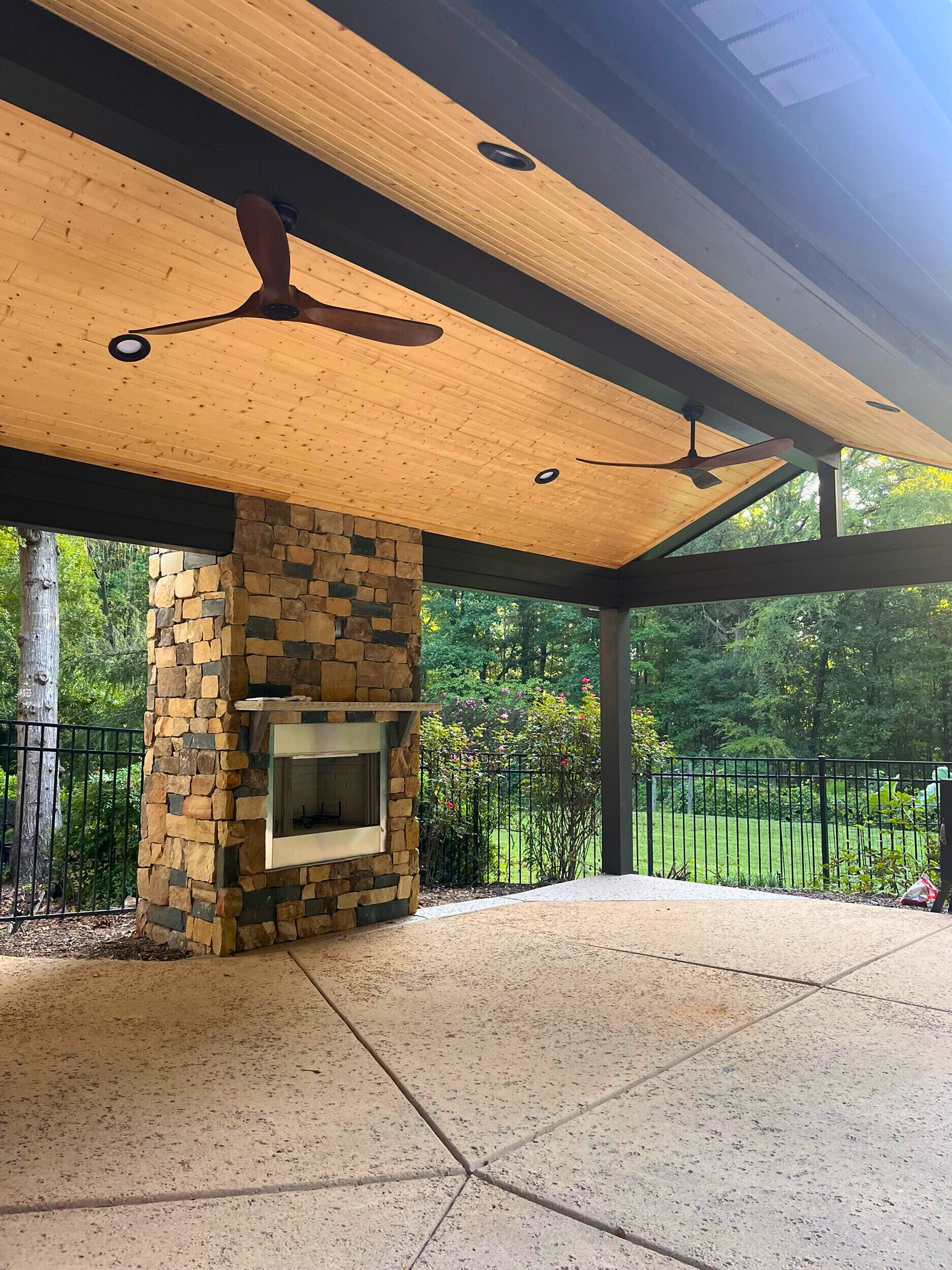 Spacious covered patio with stone fireplace and wood tongue-and-groove ceiling, ideal for a Fort Mill outdoor living space.