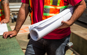 man holding roll of construction drawings