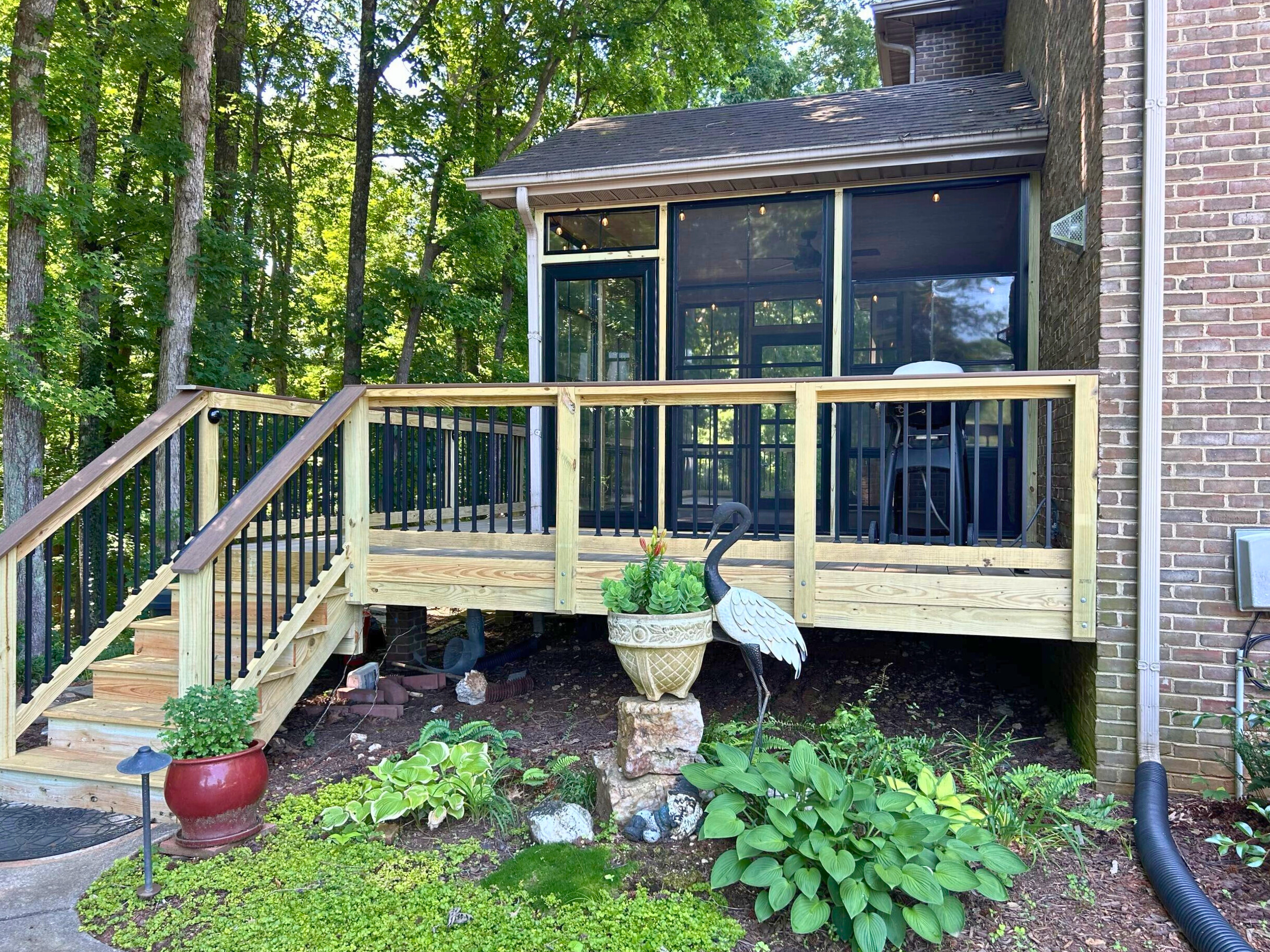 New wood deck leading to a screened porch addition on a brick home in Fort Mill, SC.