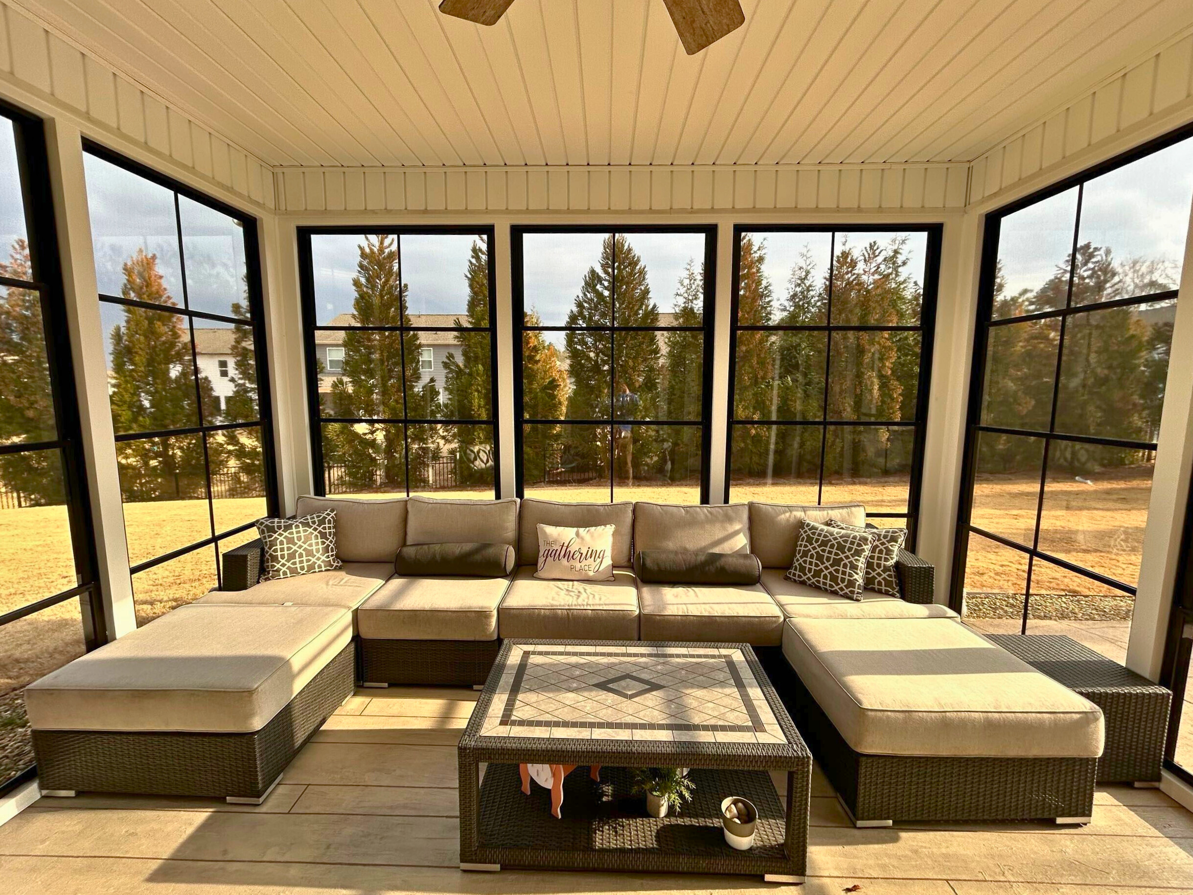 Inviting Eze-Breeze screened porch interior with ceiling fan and view of trees, designed by a Fort Mill porch builder.
