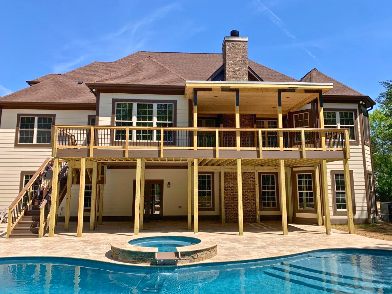 Expansive two-story deck with covered section and stairs leading to a backyard pool in Fort Mill, SC.