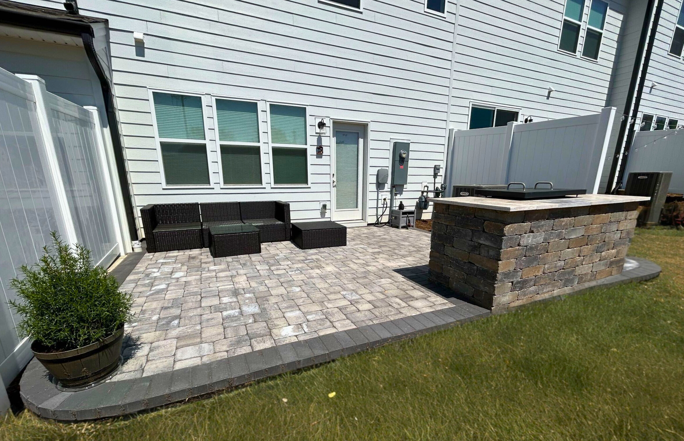 Beautiful paver patio with a built-in stone grill surround, designed and installed by a Fort Mill patio builder.