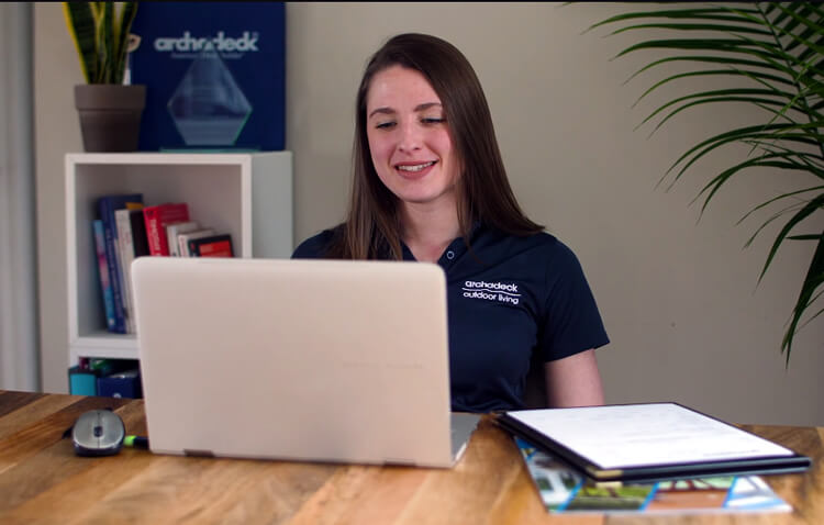 Archadeck employee sitting in front of a laptop for a virtual design consultation
