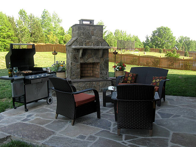 outdoor patio fireplace next to barbecue and outdoor furniture