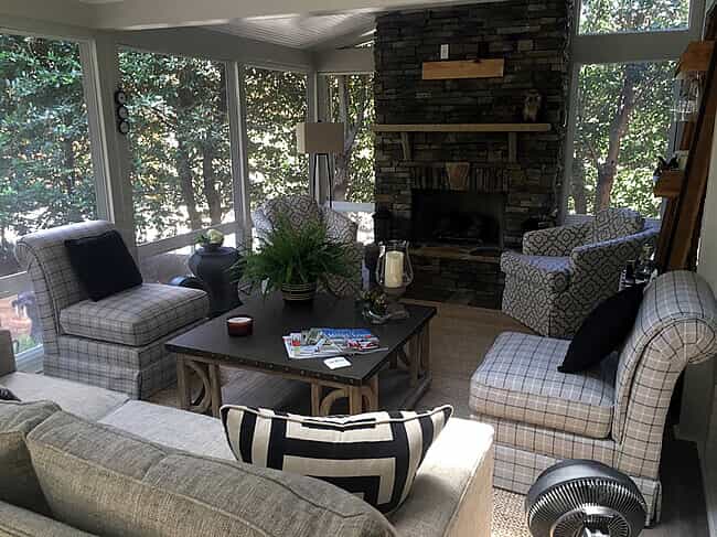 4-season porch/ sunroom with couches and fireplace
