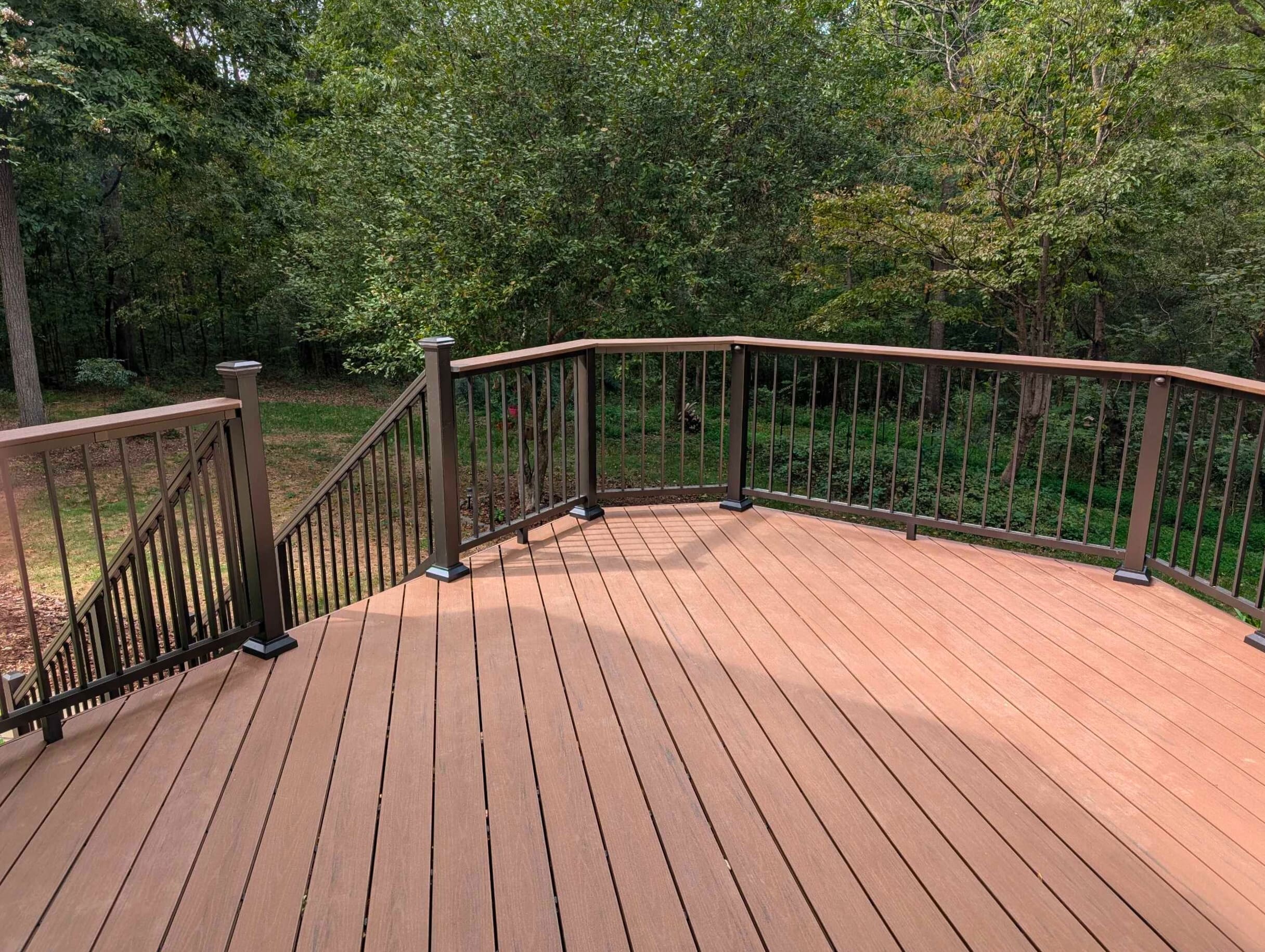 Brand new composite deck with dark brown railing and light brown decking, built by deck builders in Monroe NC.