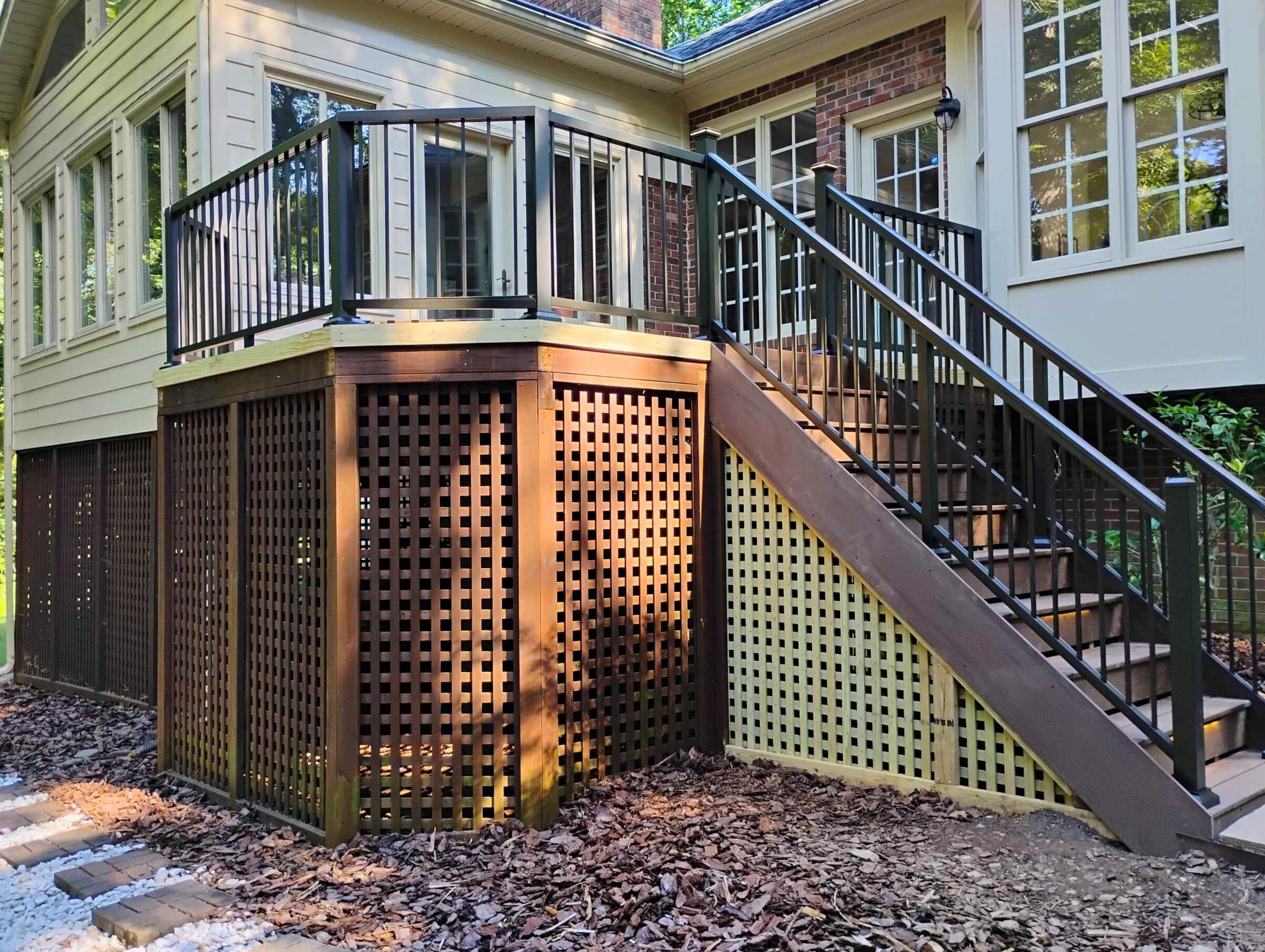  Multi-level composite deck with dark lattice skirting and black railings, leading to a backyard in Monroe NC.