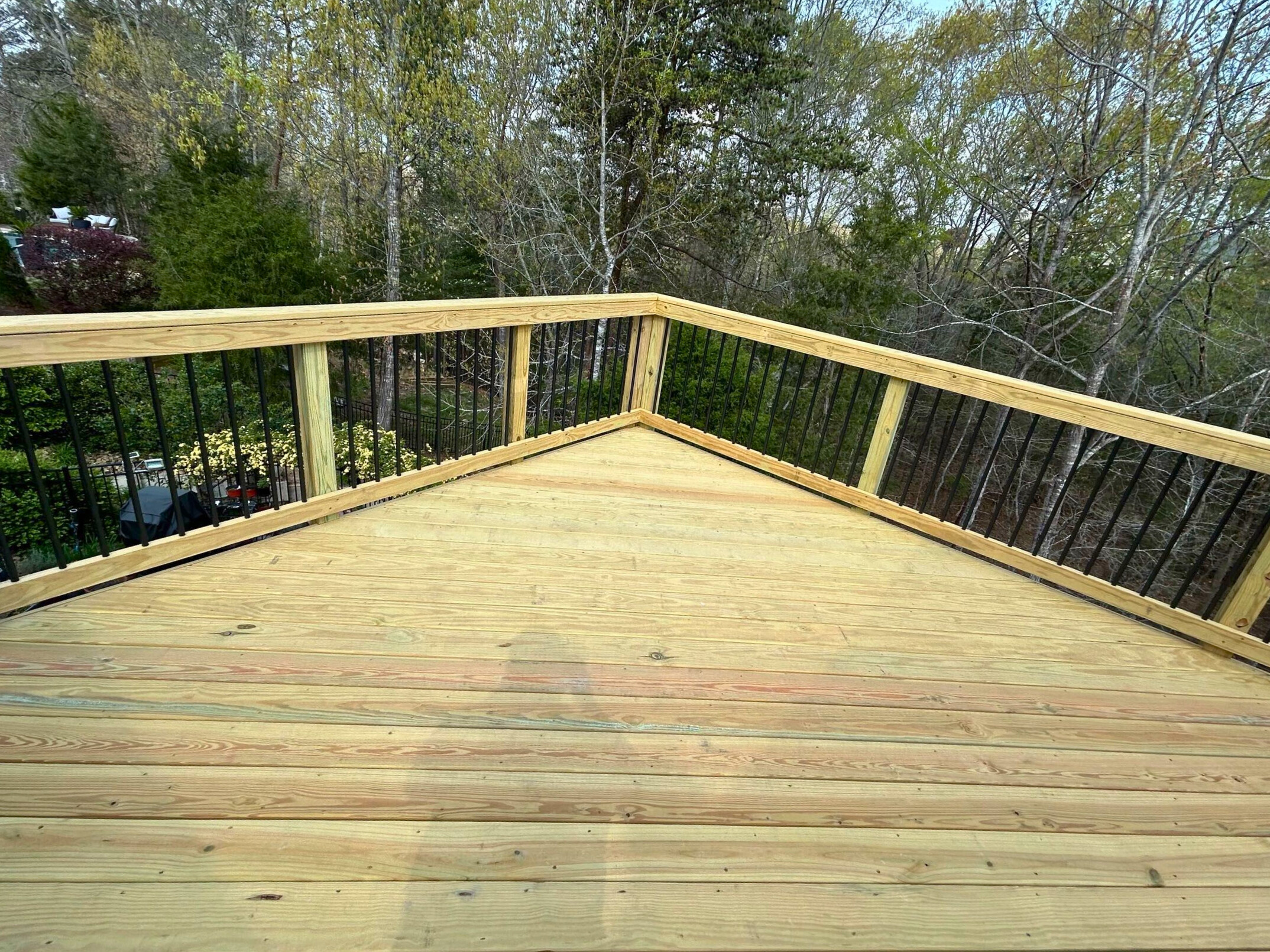 Elevated composite deck with stairs leading to a poolside patio, built in Tega Cay