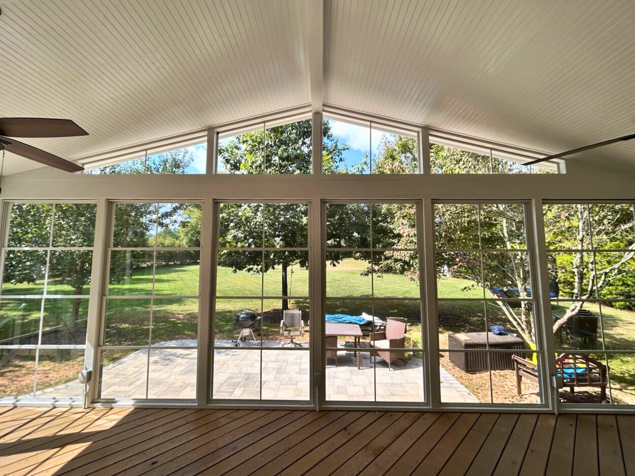 Spacious three-season room with large windows and vaulted ceiling, overlooking a backyard patio in Waxhaw, NC.