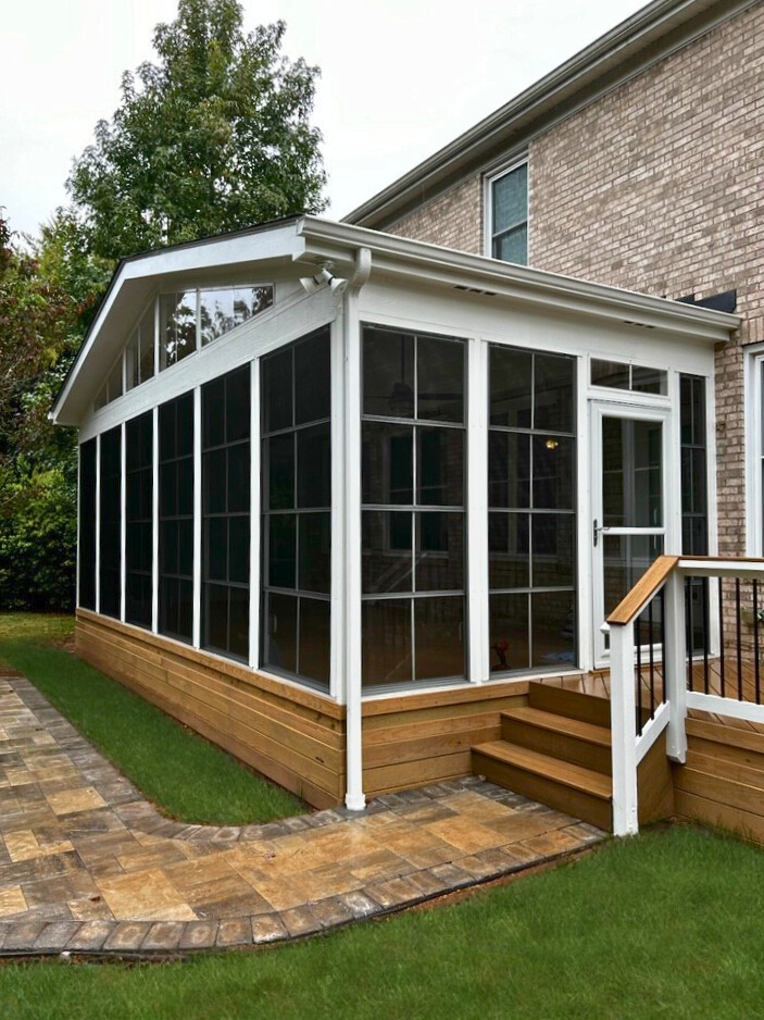 Eze-Breeze window system screened porch with white framing and integrated steps to a paver walkway in Waxhaw, NC.