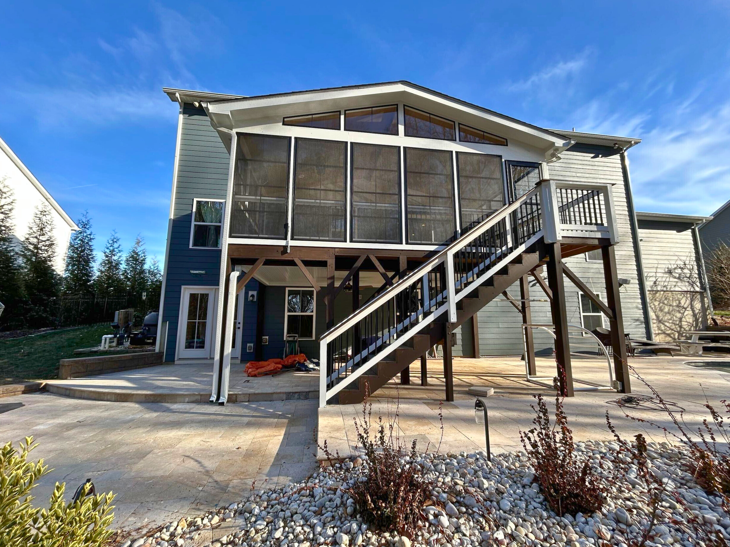 Custom elevated screened porch with outdoor staircase and ground-level patio, built by Archadeck in Waxhaw, NC.