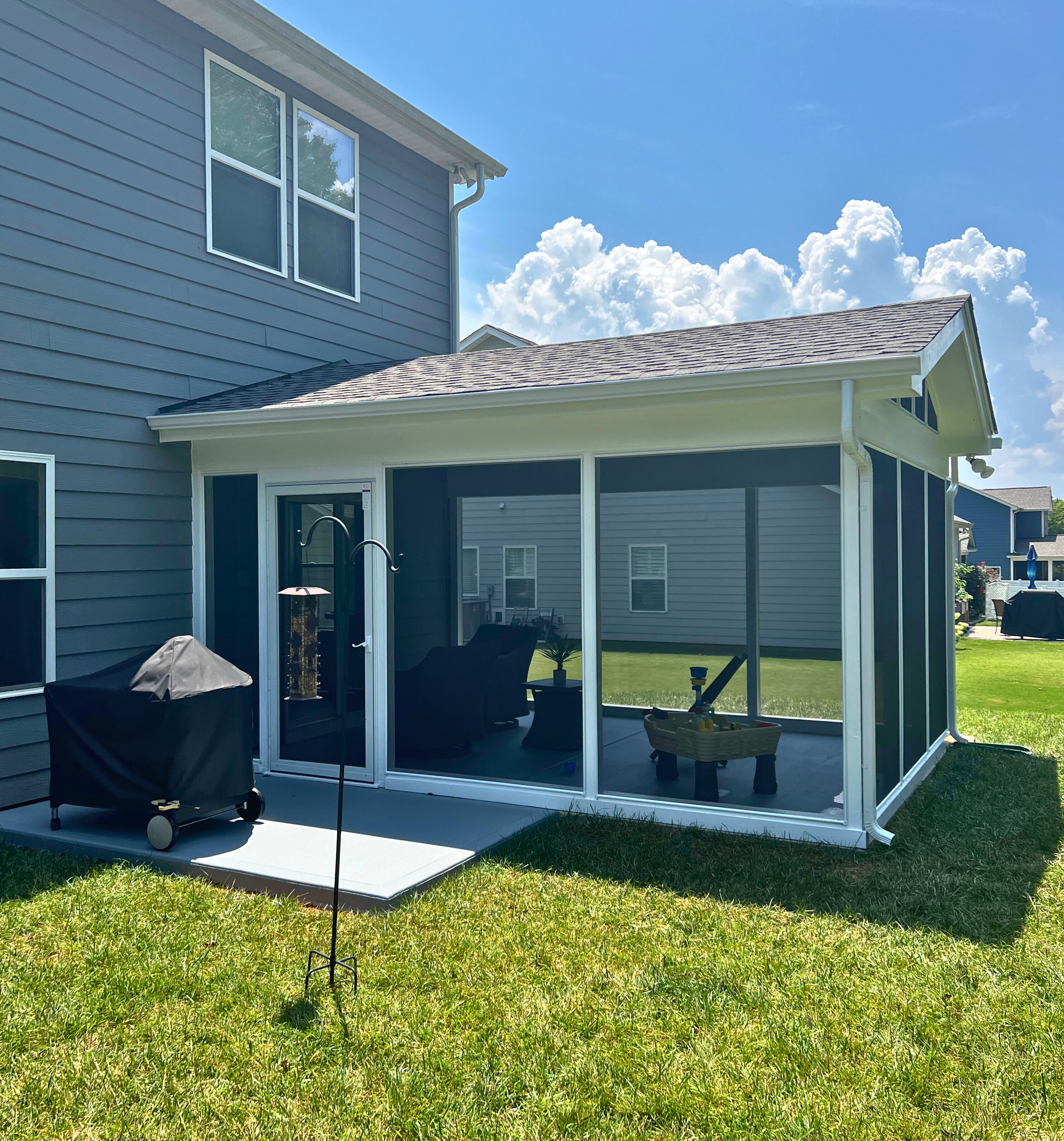 Ground-level screened porch addition with white framing on a Waxhaw, NC home, installed by Archadeck.