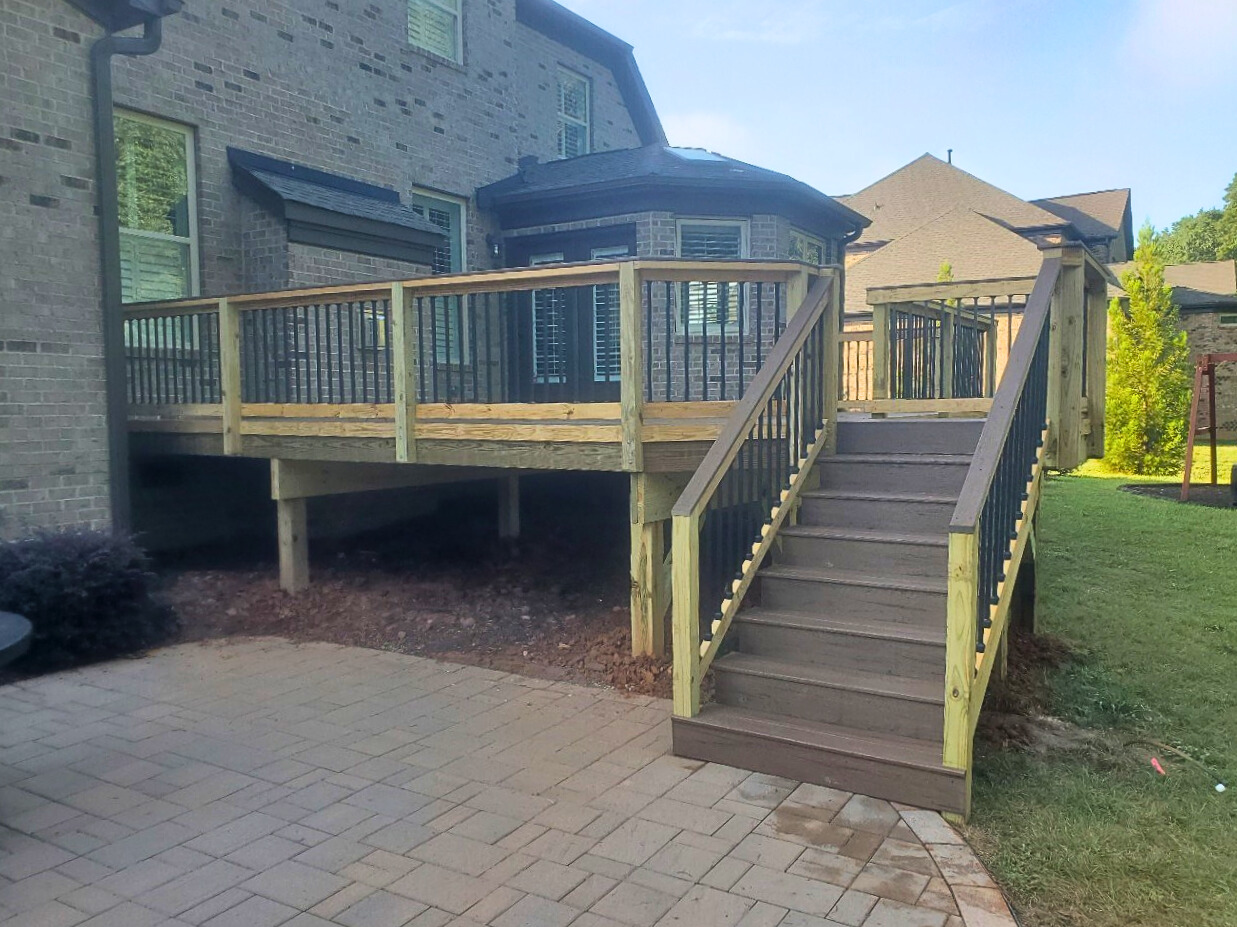 New composite deck with dark railings overlooking a wooded area, built by Archadeck, a trusted Waxhaw deck builder.