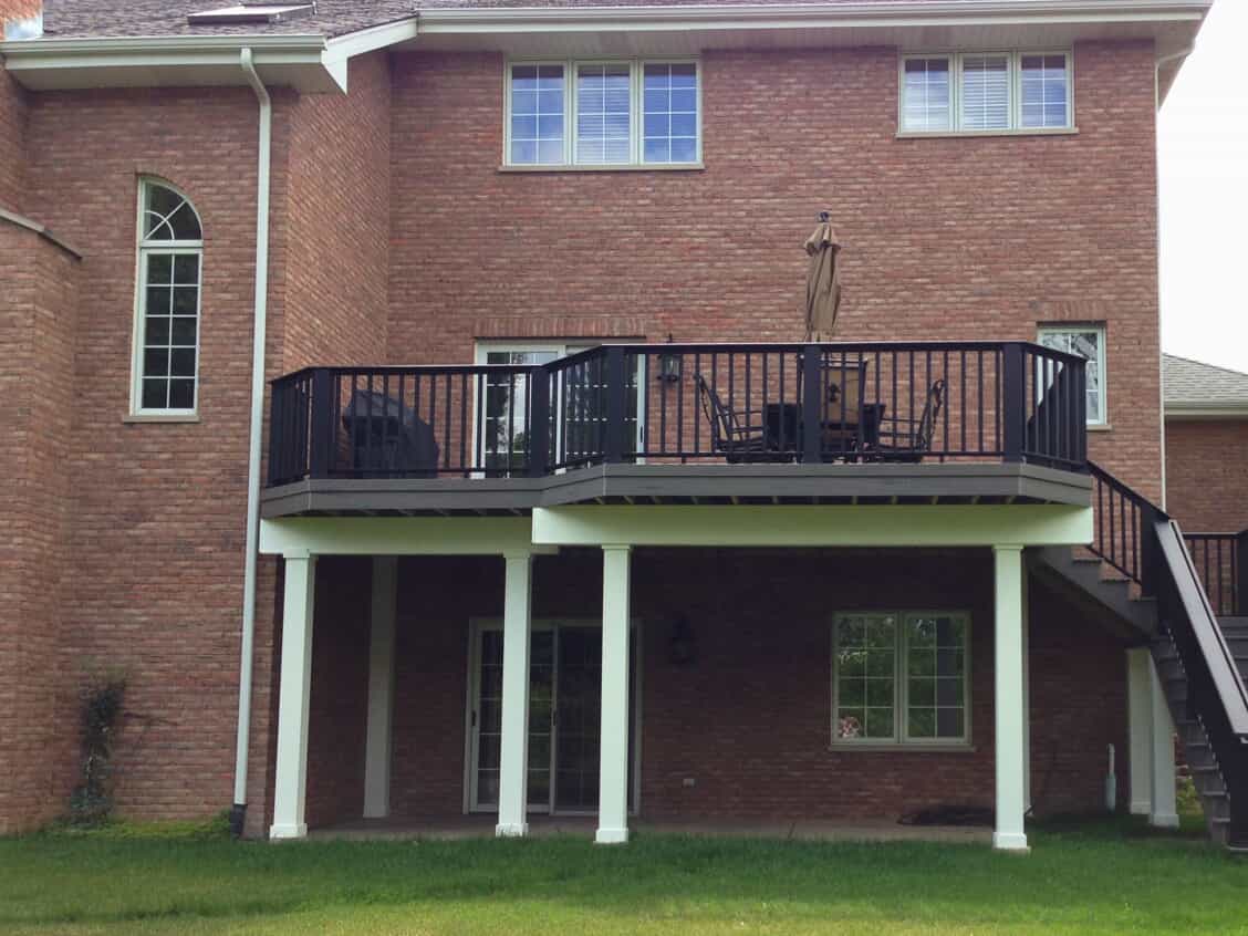 Expansive multi-level composite deck with black railings and white columns on a brick home in Frankfort, IL