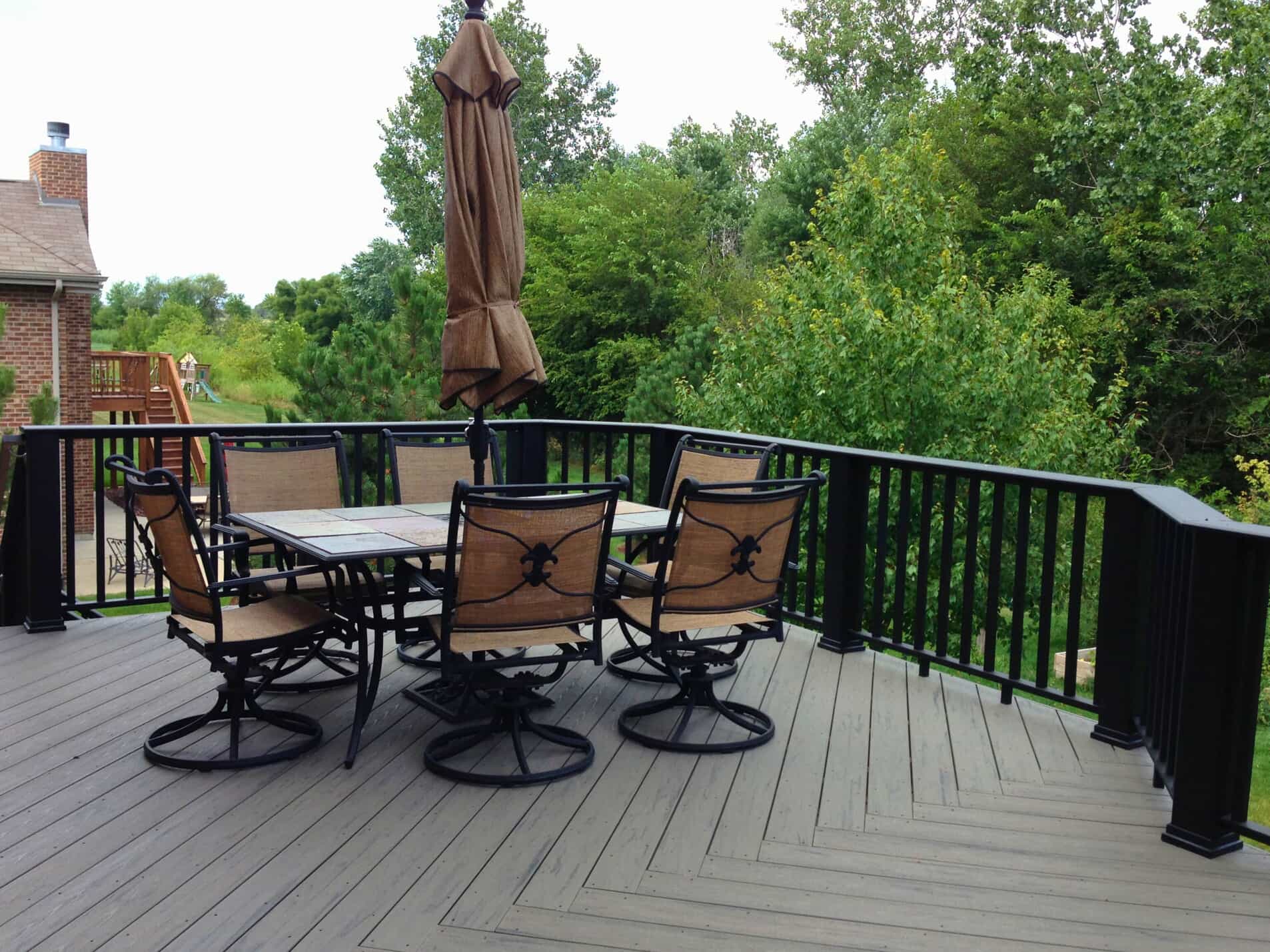 TimberTech composite deck with black aluminum railings and outdoor dining furniture in Frankfort, IL