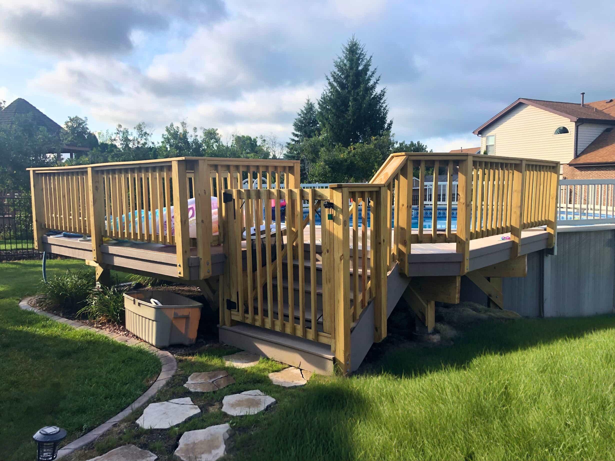Multi-level wooden deck with composite main surface connecting to an above-ground pool in Frankfort, IL