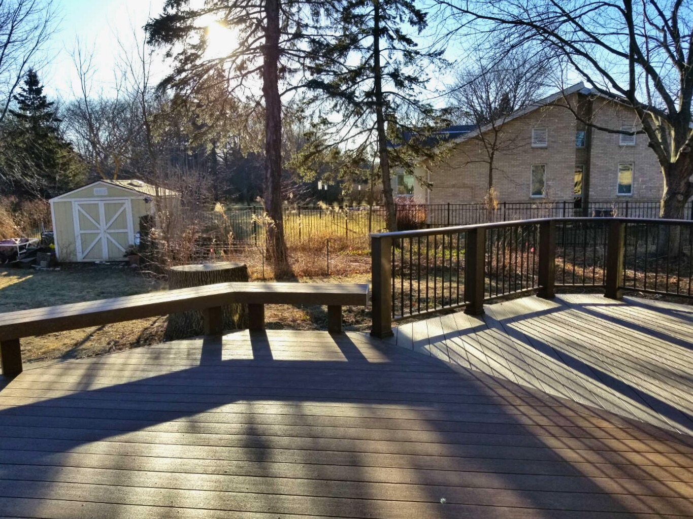 Composite deck in Wheaton, IL with gray decking, white railings, black balusters, and an integrated storage area with a trap door. Modern deck and house color combination.