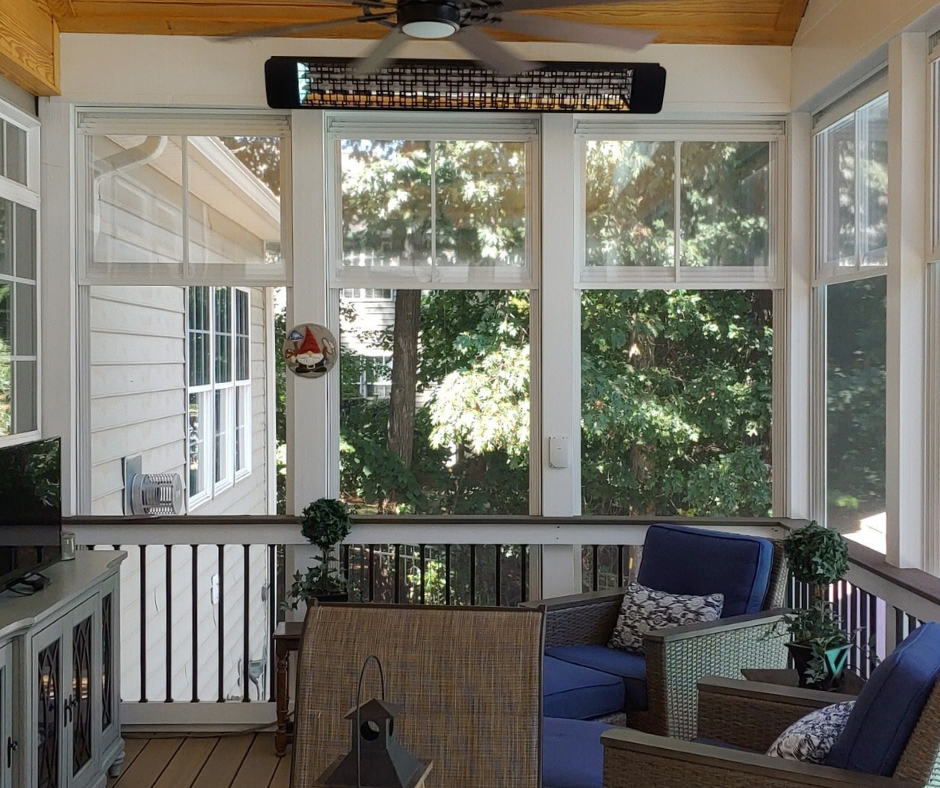 A sunroom with an Eze Breeze porch system, featuring a sectional sofa and fireplace.