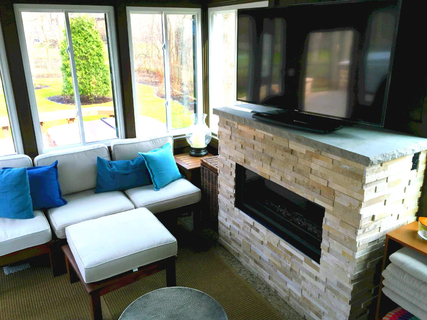 Sunroom with a fireplace, a TV and a sofa