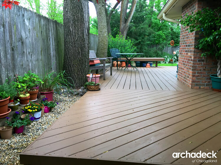 Backyard wood deck surrounded by plants