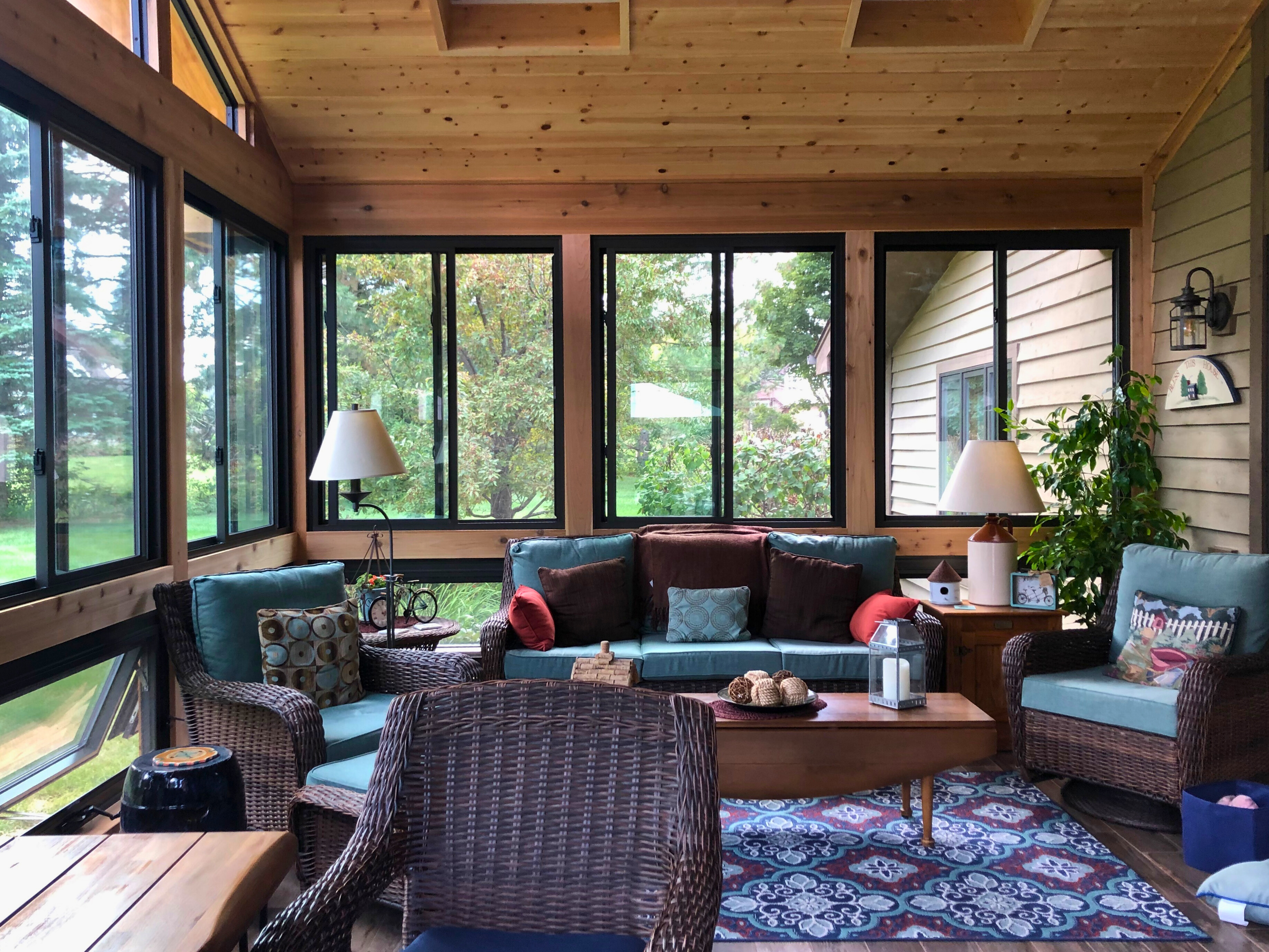A 3-season porch with large windows and blue chairs.