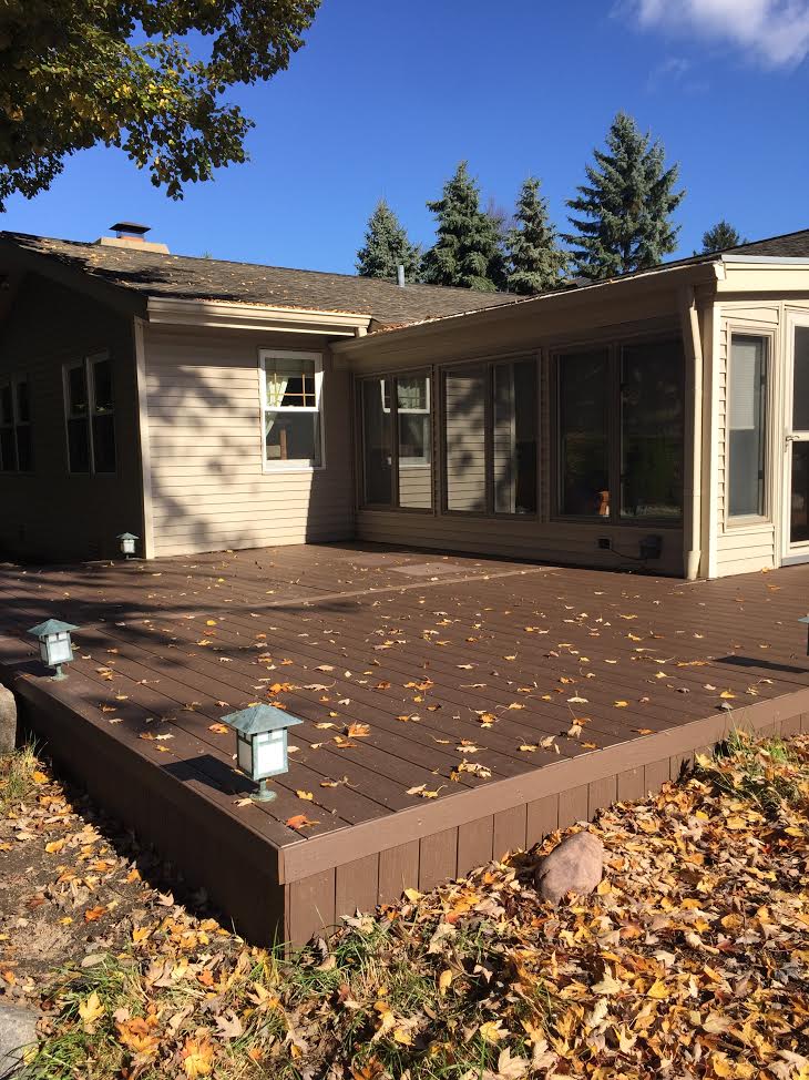 A new deck made of composite decking with a sunroom attachment.