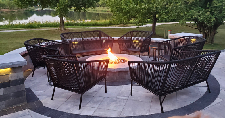 Custom gas fire pit installation in Chicagoland with paver patio, circular design, and integrated low-voltage lighting.