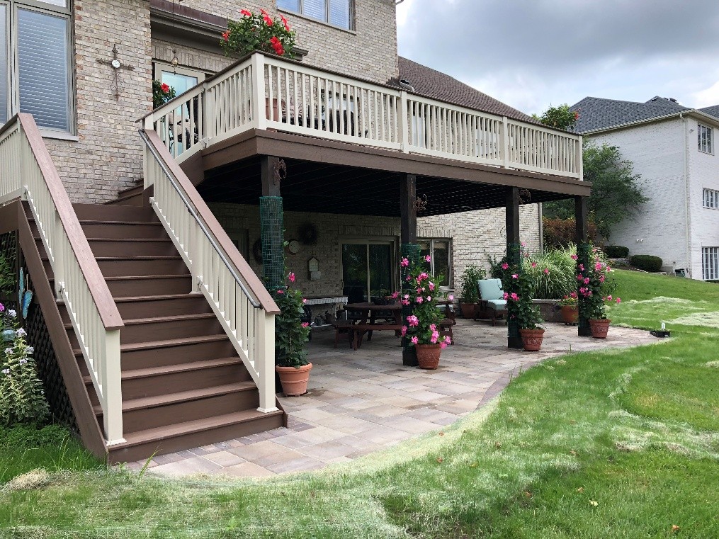 backyard deck with pink flowers around poles