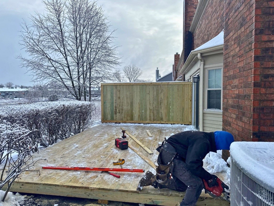 deck installers building a deck in the snow