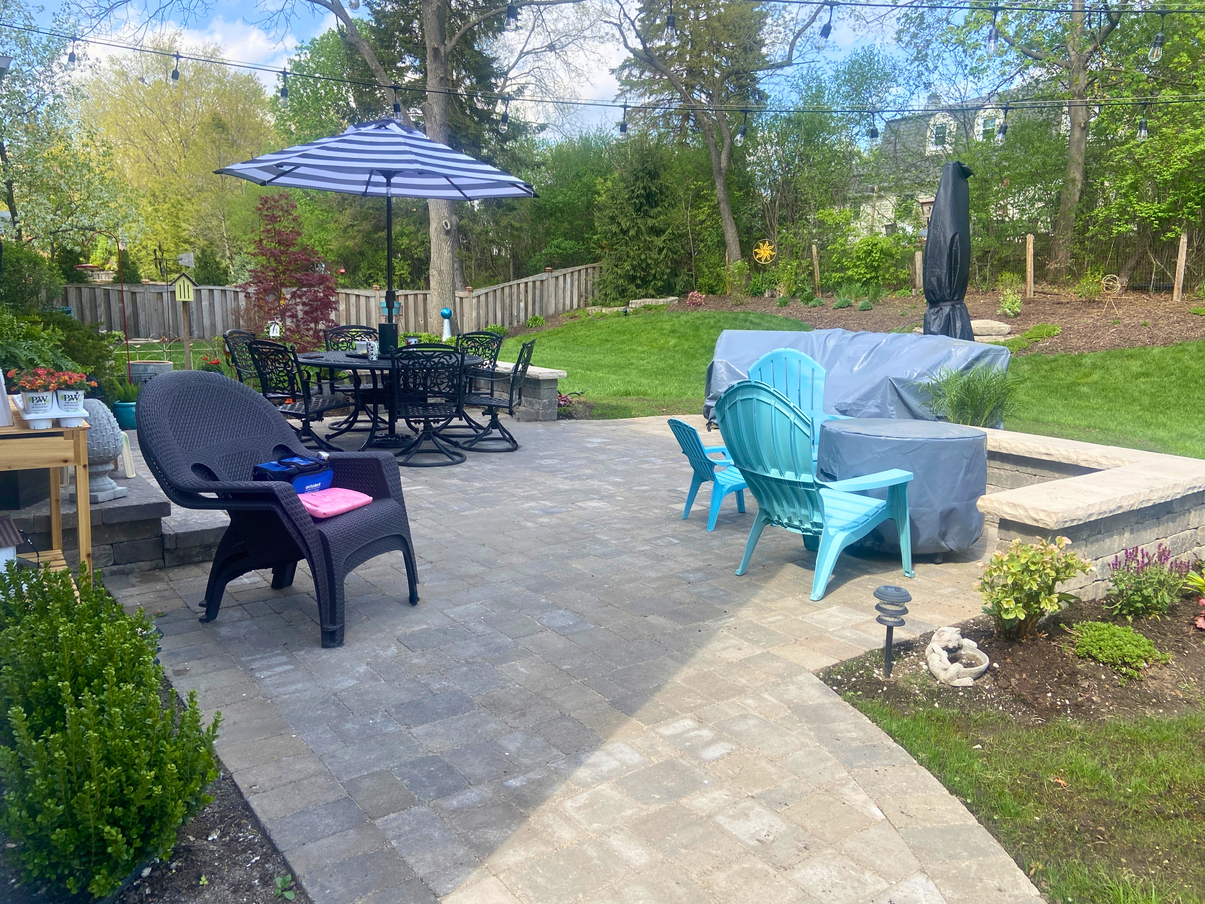 Large paver patio with a fire pit and outdoor furniture in a Libertyville IL backyard.