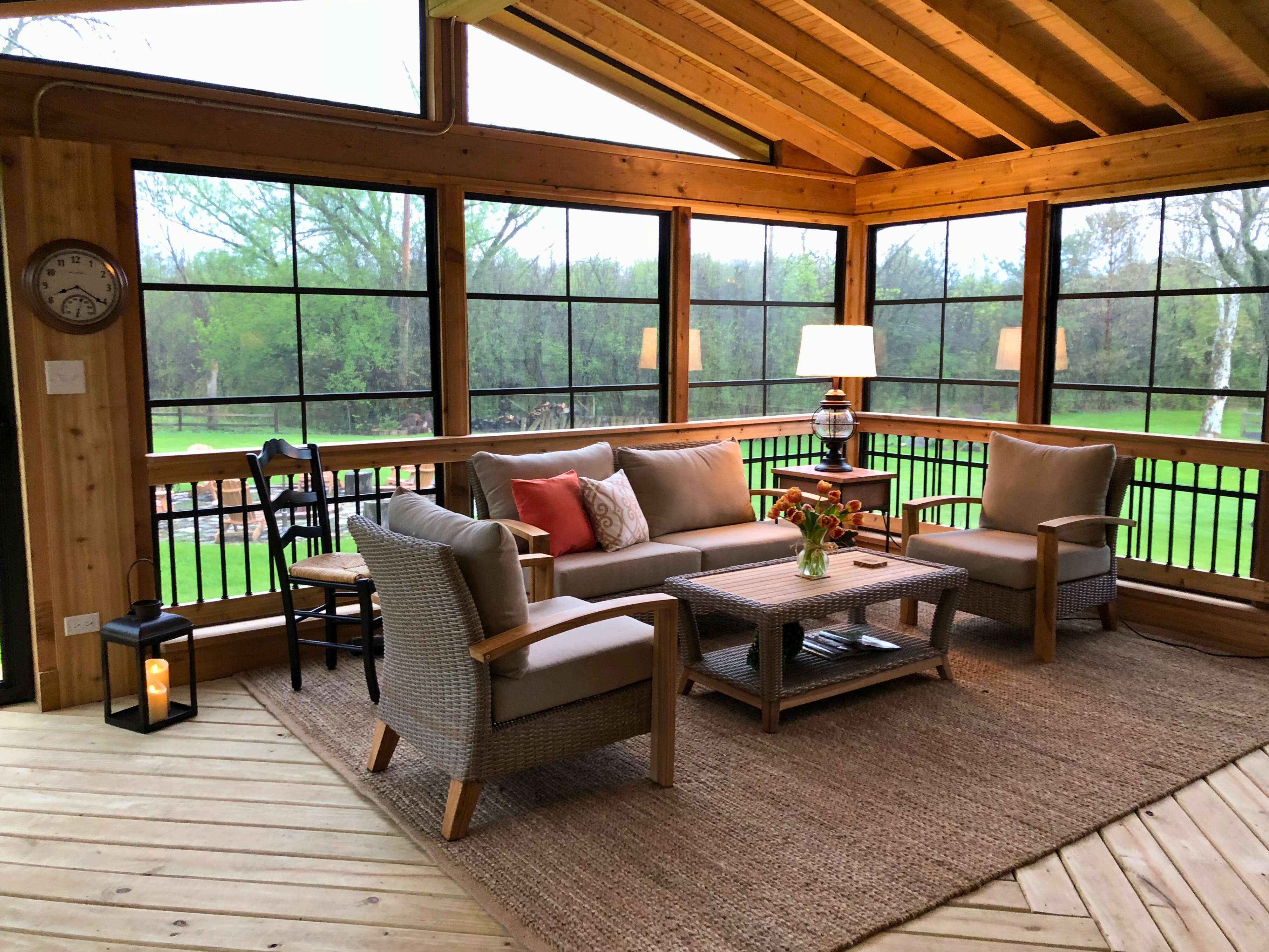 nterior of a screened porch with wood ceiling and comfortable furniture, built by porch builders in Libertyville IL.