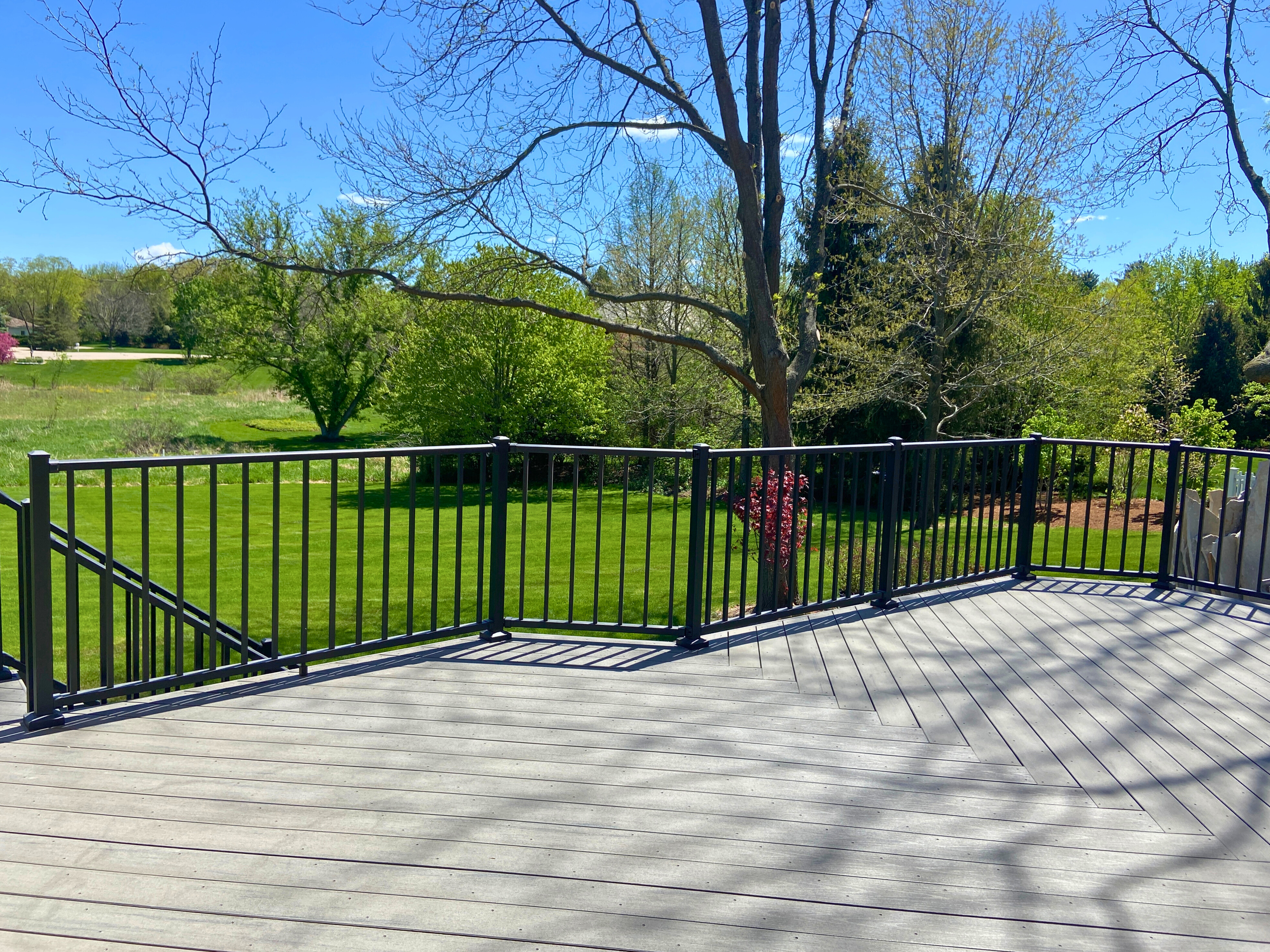 Large composite deck with light grey boards and black metal railing, overlooking a green landscape, Barrington, IL
