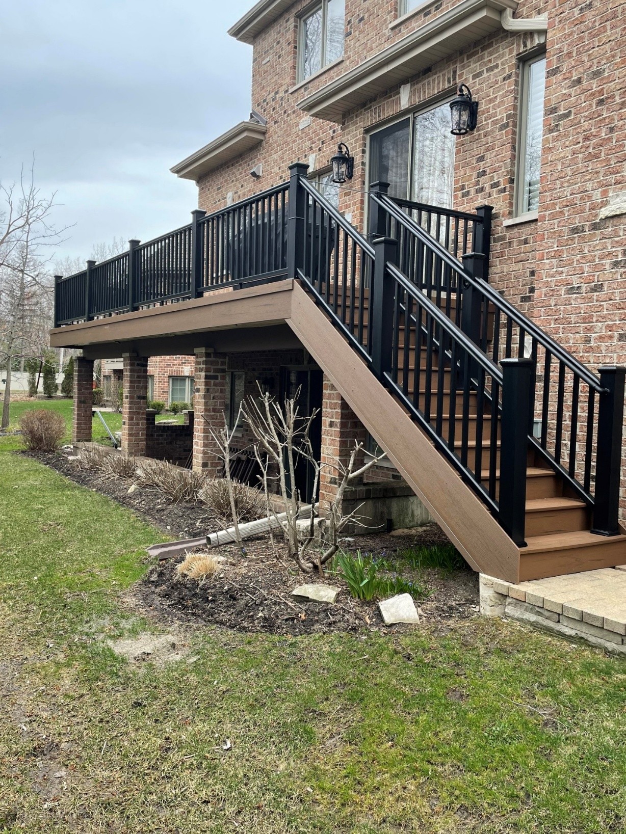 A bright and airy three-season porch with large windows, a wood plank ceiling with a ceiling fan, and comfortable outdoor furniture. 