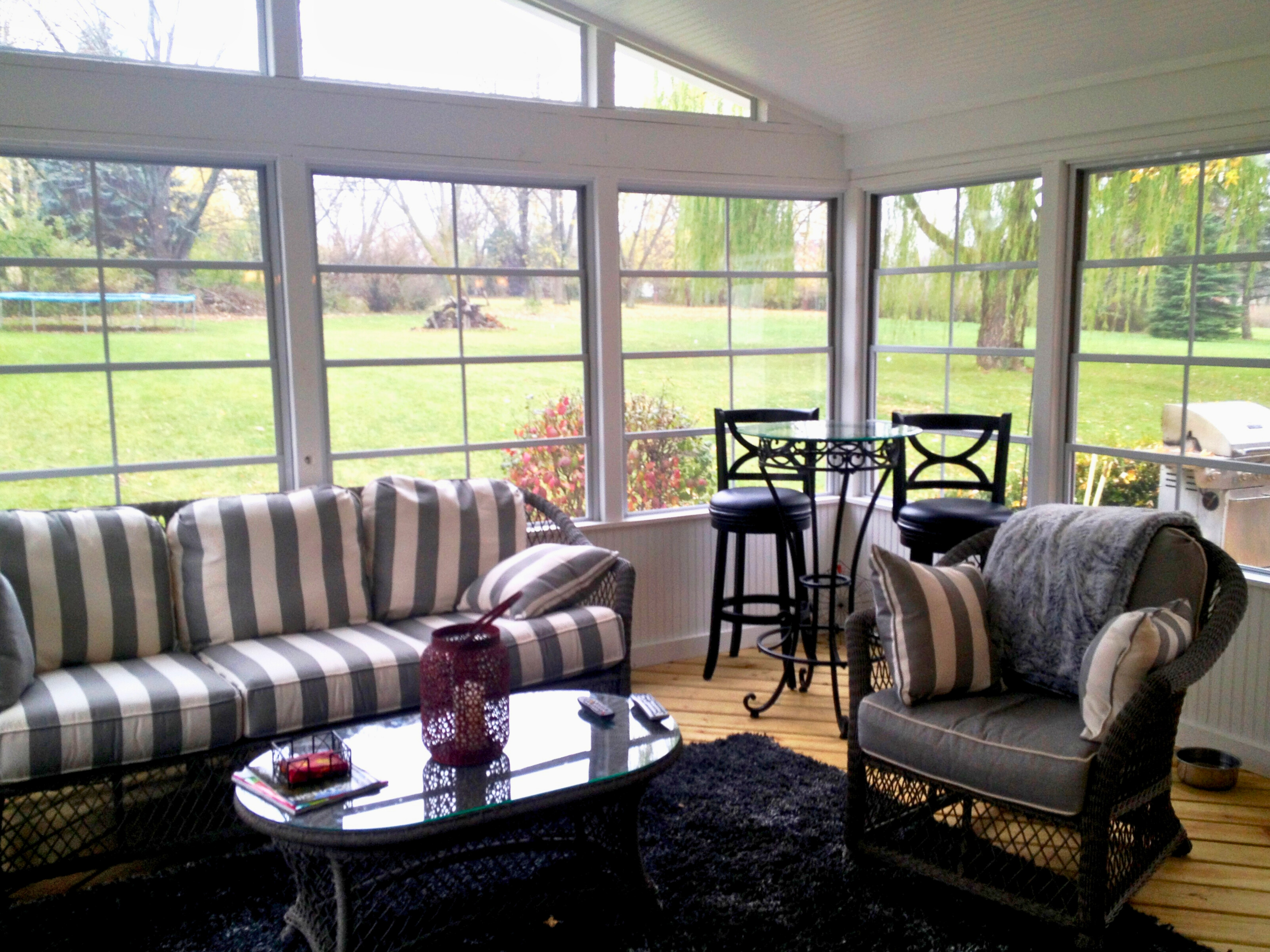 Detached four-season room with large windows and a grey composite deck with white railing lights, Barrington, IL.