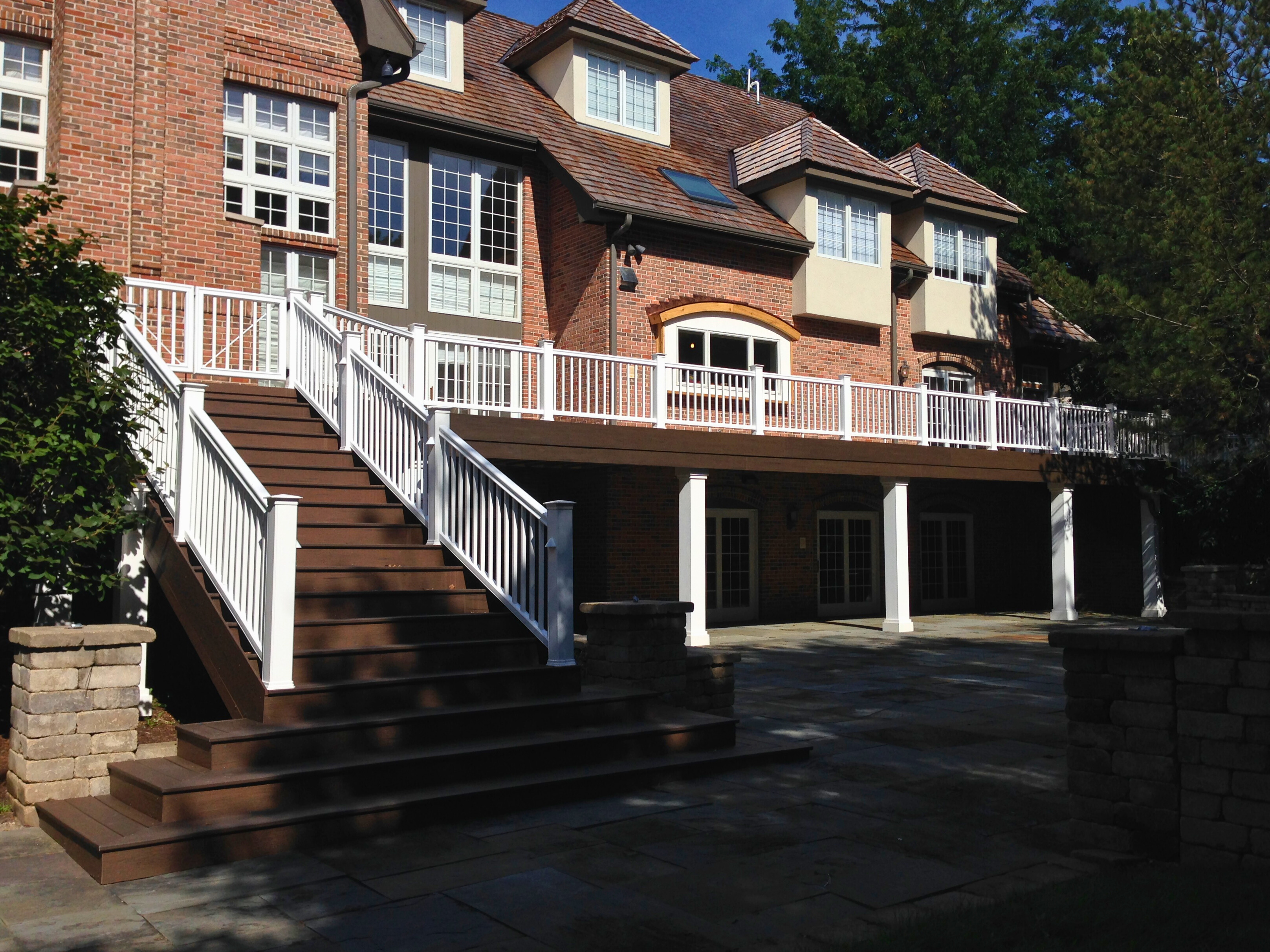 Second-level composite deck with dark brown railing attached to a brick home, Barrington, IL.
