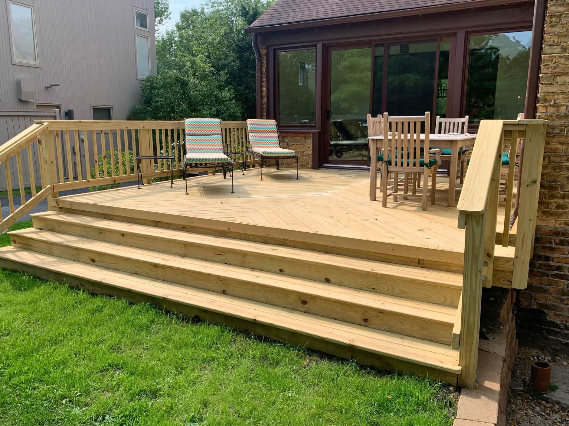Spacious new cedar wood deck with wide steps and wood railings on a Highland Park home