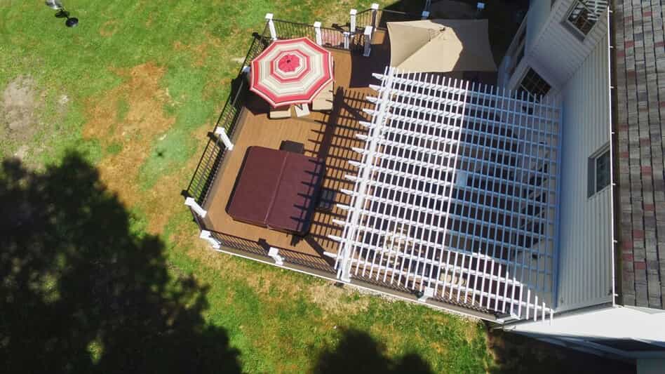 Aerial shot of backyard with pergola, umbrella & covered jacuzzi