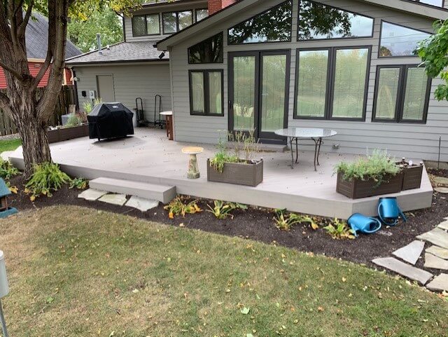 Custom backyard deck with outdoor kitchen and planter boxes